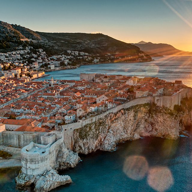 Photo shows beautiful sunrise at Dubrovnik old town. Photo also shows the blue sea and old town wall where the sunlights turned the town in golden color.